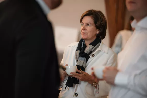 Vrouw kijkt rechts met koffie in de hand